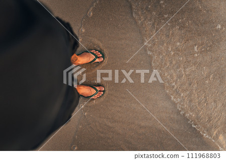 waves and naked feet on a sand beach in evening waves and naked feet on a sand beach in evening 111968803