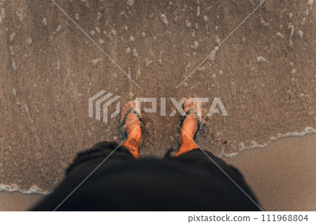 waves and naked feet on a sand beach in evening waves and naked feet on a sand beach in evening 111968804