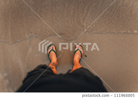 waves and naked feet on a sand beach in evening 111968805