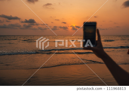 Sunset on the beach and mobile phone taking photos 111968813