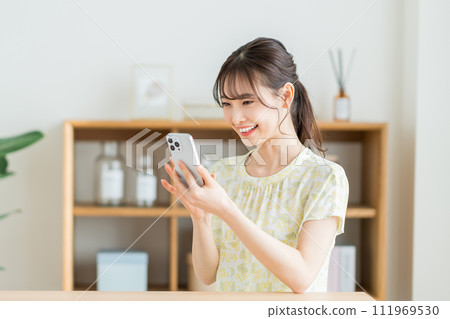 A young woman operating a smartphone 111969530