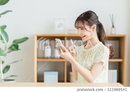 A young woman operating a smartphone A young woman operating a smartphone 111969541