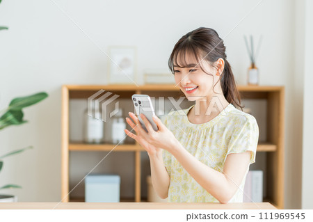 A young woman operating a smartphone A young woman operating a smartphone 111969545