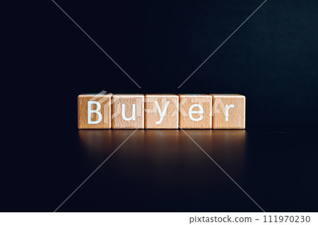 Wooden blocks form the text "Buyer" against a black background. Wooden blocks form the text "Buyer" against a black background. 111970230