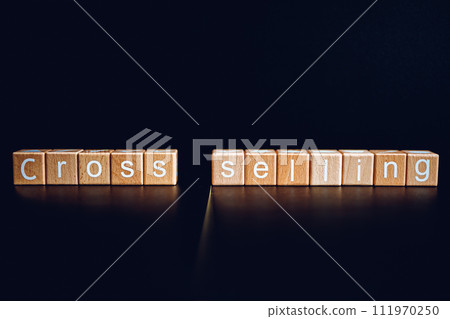 Wooden blocks form the text "Cross selling" against a black background. Wooden blocks form the text "Cross selling" against a black background. 111970250