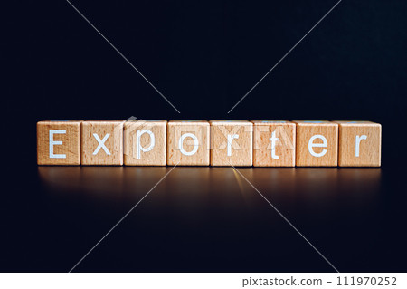Wooden blocks form the text "Exporter" against a black background. Wooden blocks form the text "Exporter" against a black background. 111970252