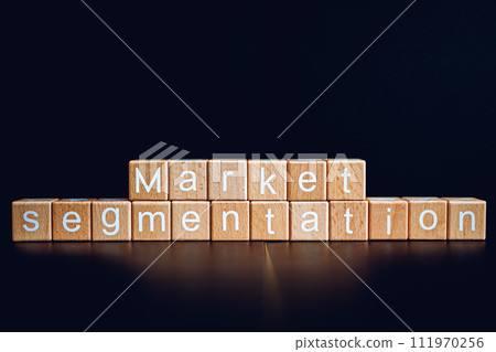 Wooden blocks form the text "Market segmentation" against a black background. 111970256
