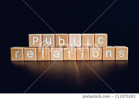 Wooden blocks form the text "Public relations" against a black background. 111970261