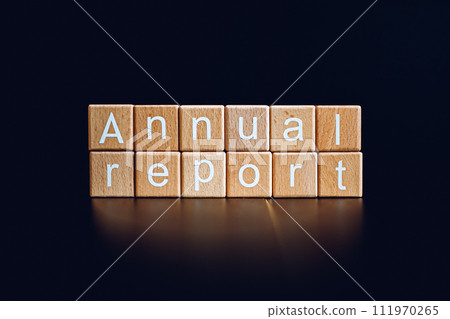 Wooden blocks form the text "Annual report" against a black background. Wooden blocks form the text "Annual report" against a black background. 111970265