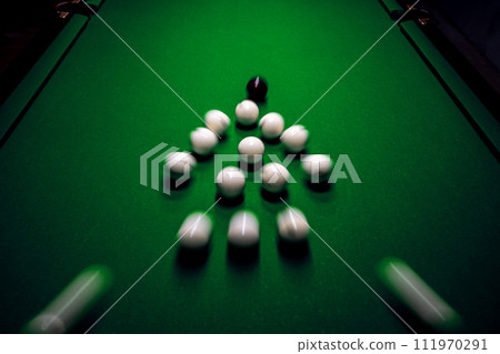 Strong hit by a player with a billiard cue on the ball 111970291