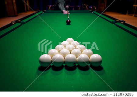 Billiard man player arm breaking the pyramid by striking the ball with cue stick 111970293