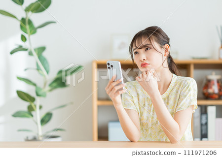 A young woman checking on her smartphone. 111971206