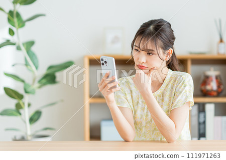 A woman checking on her smartphone. 111971263