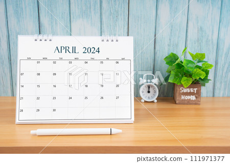 April Monthly desk calendar for 2024 year and alarm clock. 111971377