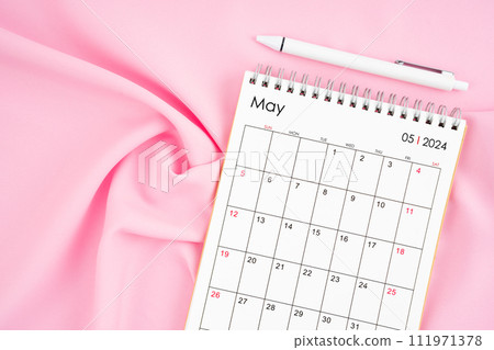 May 2024 month calendar and pen on pink fabric background. 111971378