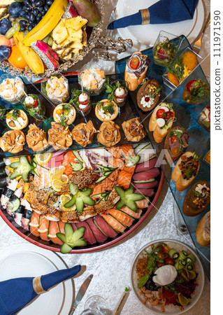 A buffet in a chic hotel with seafood, sushi, salads, fruits and pastries A buffet in a chic hotel with seafood, sushi, salads, fruits and pastries 111971590