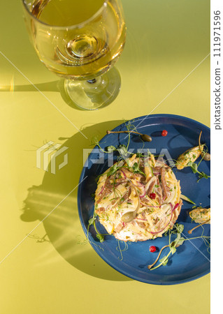 Seafood salad with white wine on blue plate, perfect for a refreshing meal. 111971596