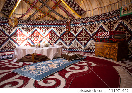 Kazak yurt interior with traditional felt carpets and furniture 111971632