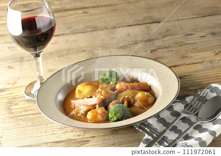Hot beef stew with lots of ingredients such as broccoli, carrots, and shimeji mushrooms, and red wine. 111972061