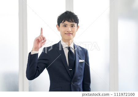 一位穿著訂製西裝並指著的商人 111972100