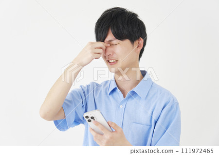 一個拿著智慧型手機的男人，眼睛疲憊，白色背景 111972465