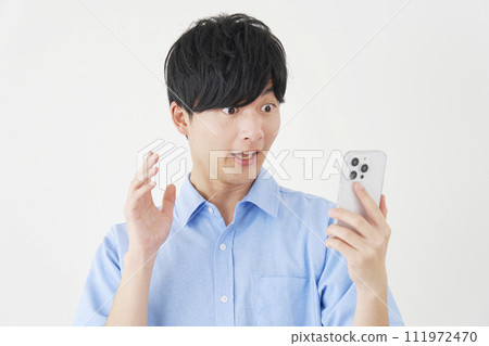 驚訝的男人看著智慧型手機，白色背景 111972470