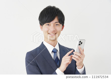 Businessman using smartphone, white background, looking at camera 111972534