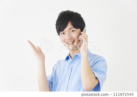 A man calling on a smartphone while pointing to the left with his palm, white background 111972545