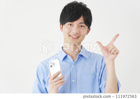 A man holding a smartphone and signing a check, white background 111972563