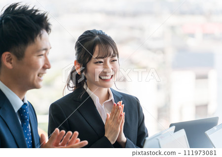 Male and female office workers/businessmen applauding and welcoming at a meeting Male and female office workers/businessmen applauding and welcoming at a meeting 111973081