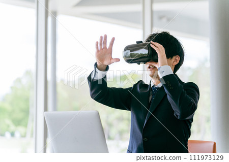 戴著 VR 護目鏡並體驗虛擬實境/元宇宙的商人/培訓師 111973129