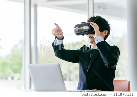 戴著 VR 護目鏡並體驗虛擬實境/元宇宙的商人/培訓師 111973131