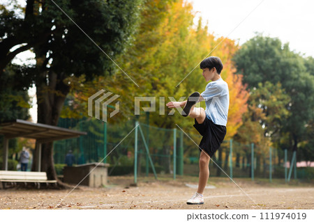 小學男孩在公園踢足球 111974019
