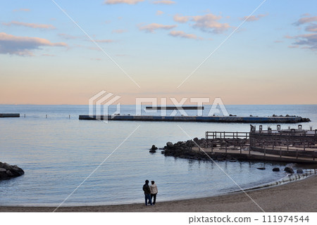 Atami beach sunset view and couple standing on the shore Atami beach sunset view and couple standing on the shore 111974544