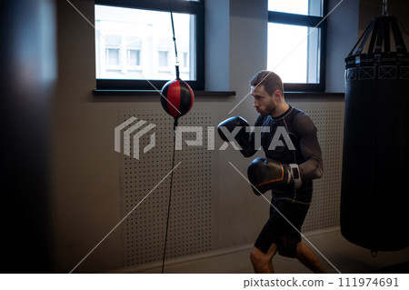 Concentrated boxer honing skills on double-end punching bag 111974691