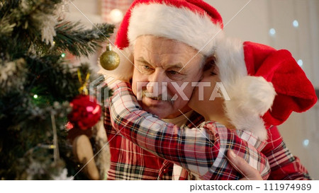 Senior man and his grandson decorating Christmas tree at home Senior man and his grandson decorating Christmas tree at home 111974989