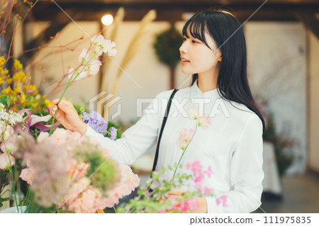 A woman who came to buy flowers at a flower shop 111975835