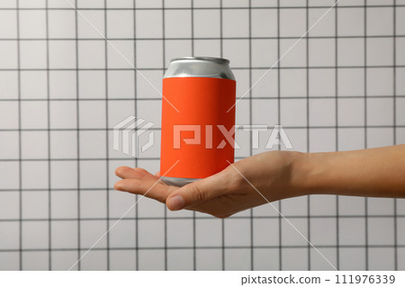 A metal can with a red wrapper in his hands A metal can with a red wrapper in his hands 111976339