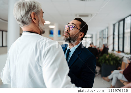 Violence against health workers. Patient is aggressive, have conflict with doctor in hospital corridor. Visitor holding doctor by coat, screaming, threatening him. Violence against health workers. Patient is aggressive, have conflict with doctor in hospital corridor. Visitor holding doctor by coat, screaming, threatening him. 111976516