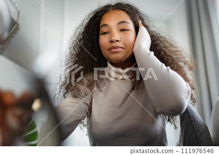Portrait of beautiful curvy woman with beautiful curly hair, looking at camera. 111976546