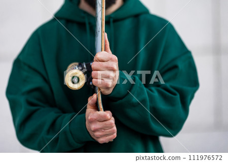 Stylish skateboarder with skateboard in front of him, close up. Concept of skateboarding as sport and lifestyle. 111976572