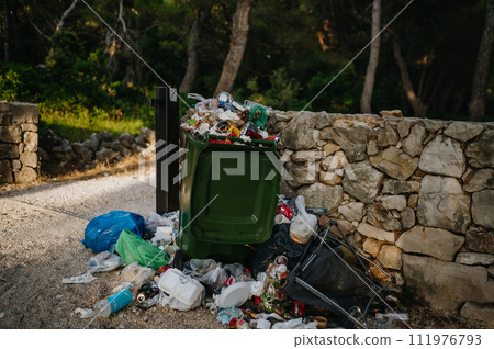 Trash in the street spilling on to the pavement. Full bins in holiday destinations. Trash in the street spilling on to the pavement. Full bins in holiday destinations. 111976793