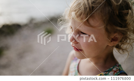 Portrait of crying blonde girl in summer outfit on walk during summer vacation, concept of beach holiday. Portrait of crying blonde girl in summer outfit on walk during summer vacation, concept of beach holiday. 111976800