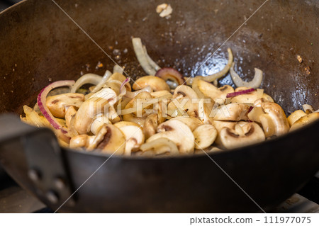 Stir Frying Mushrooms and Onions in a Wok Stir Frying Mushrooms and Onions in a Wok 111977075