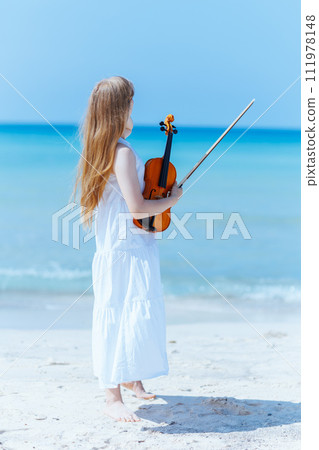 relaxed modern teenager girl in white dress on ocean coast relaxed modern teenager girl in white dress on ocean coast 111978148