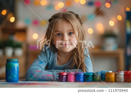 Child engaged in a colorful painting activity, surrounded by art supplies 111978940