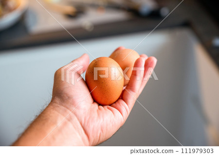 Man hand holding egg on blurred background Man hand holding egg on blurred background 111979303