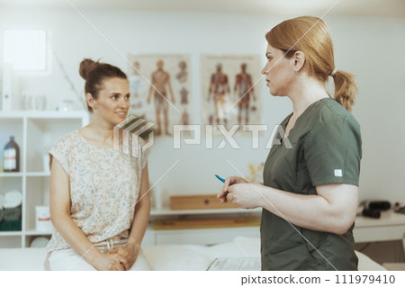 massage therapist woman in massage cabinet doing checkup 111979410