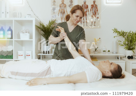 happy female massage therapist in massage cabinet doing checkup 111979420