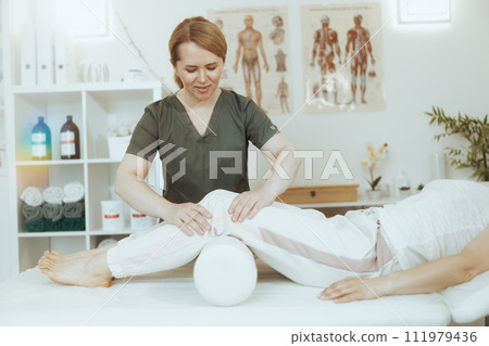 smiling therapist woman in massage cabinet doing checkup 111979436